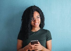 rehab centers in indiana, About Anabranch Treatment Center, about Anabranch Recovery. beautiful young Black Learn about Anabranch Recovery Center. woman with glasses smiling and using a smart phone