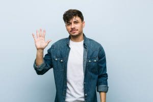 handsome young man holding up his right hand - addiction