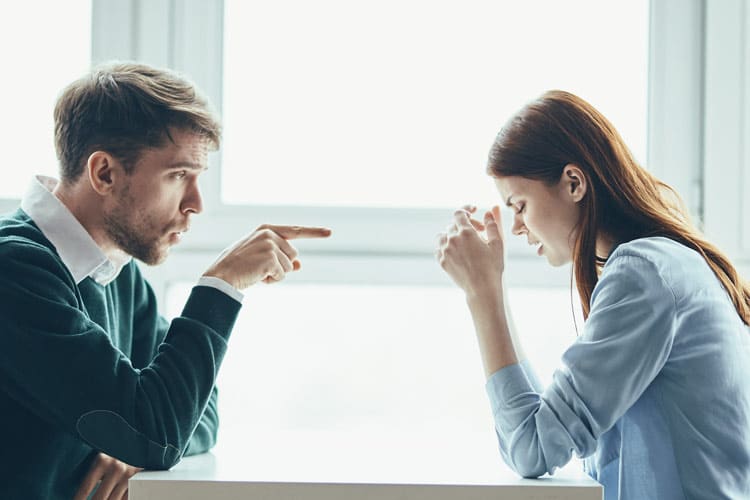 Signs of a Toxic Relationship, young man pointing his finger at the young woman sitting across the table from him - toxic relationships