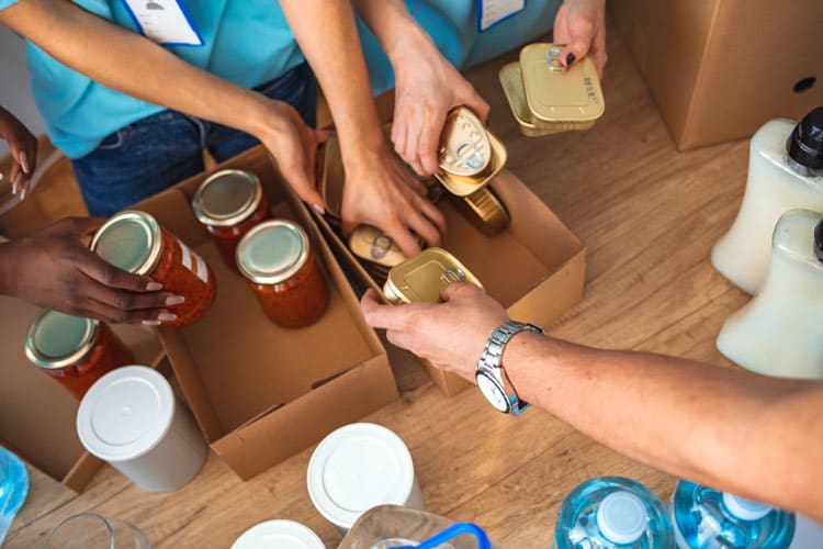 overhead shot of volunteers packing food items - giving back